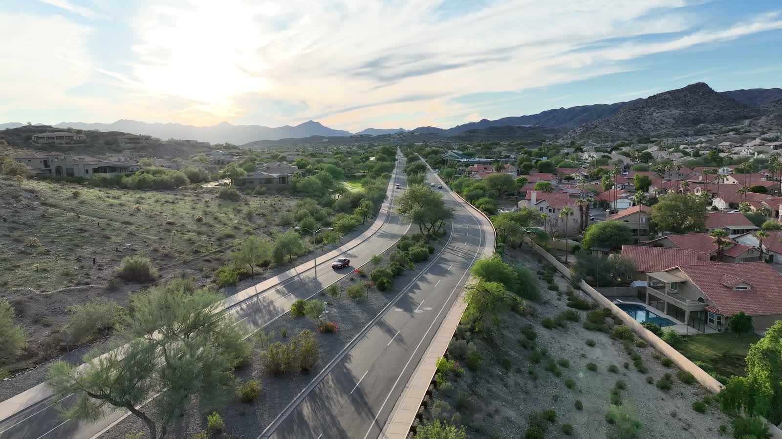 The road curving through the Ahwatukee Foothills, homes stepping up toward the ridge