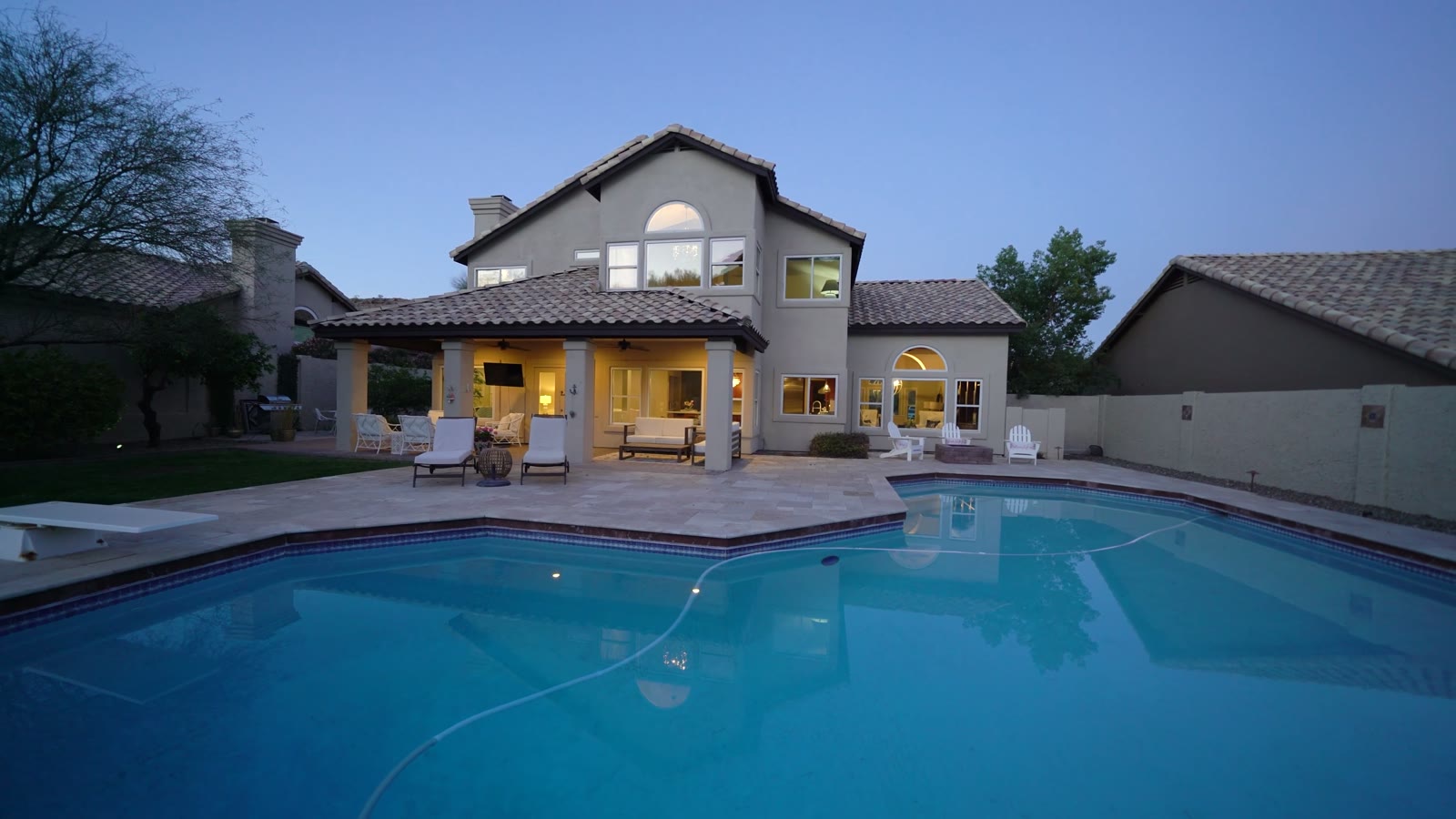 A home in Mountain Park Ranch at twilight, the pool and patio lit