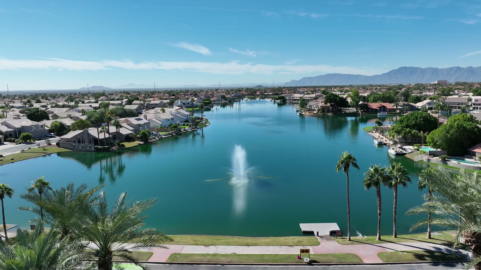 The lake and fountain at the center of Lakewood, palms and homes around it