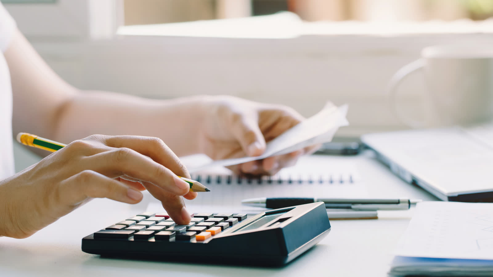 A calculator and household bills on a table