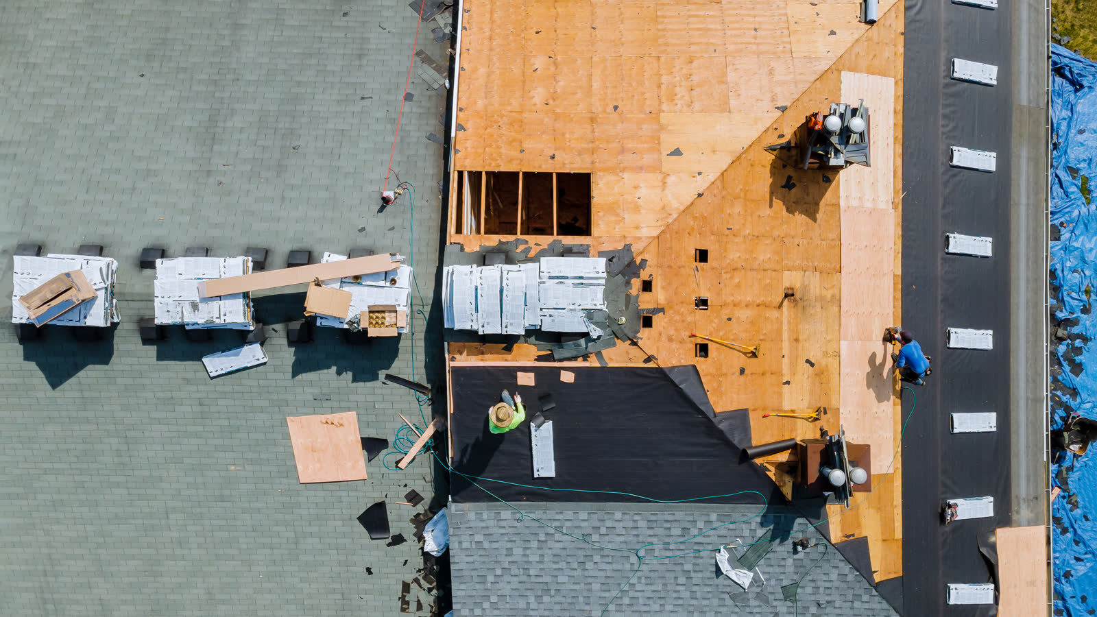A roofer fastening shingles on a residential roof