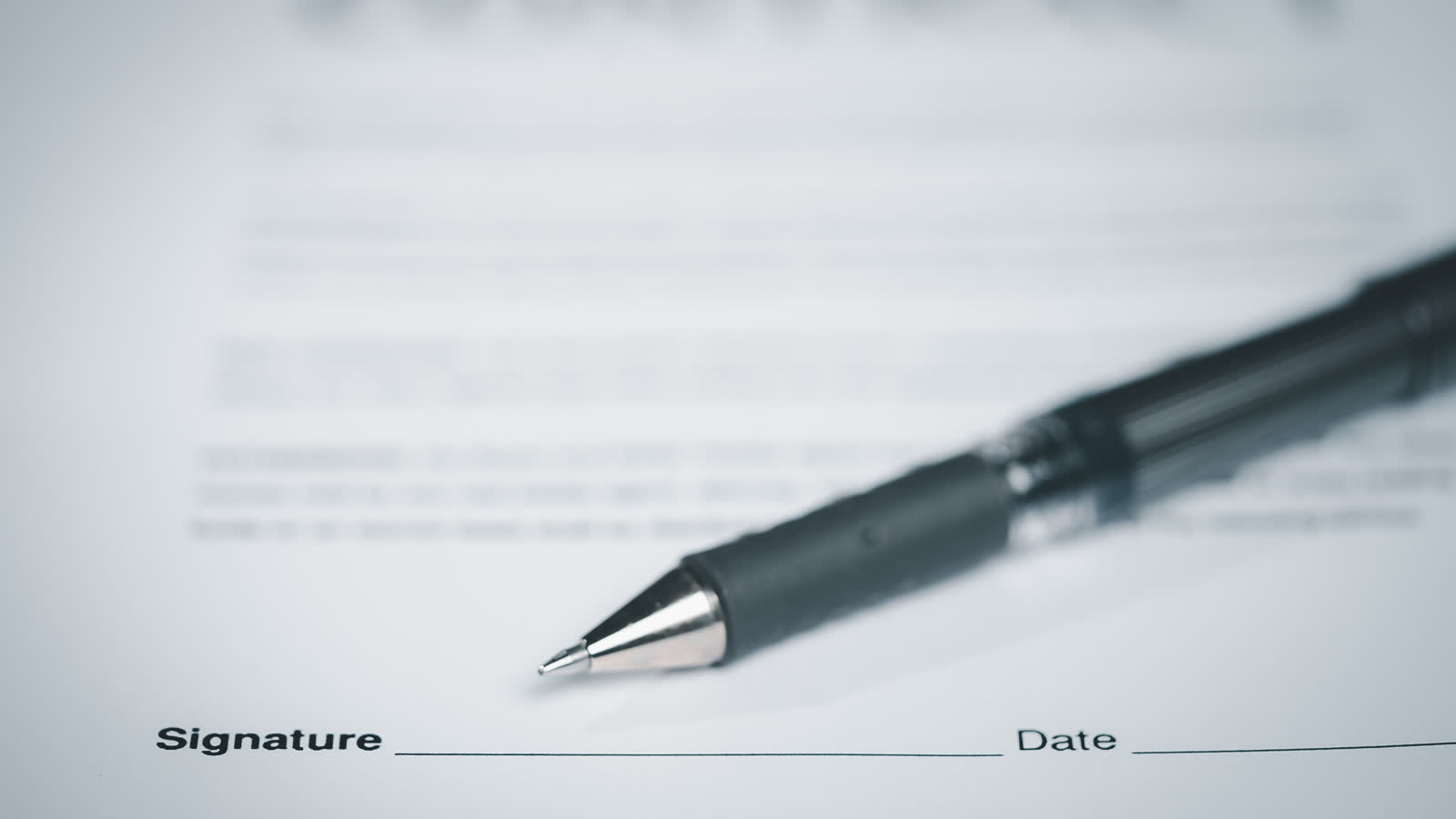 A pen resting on a signed contract