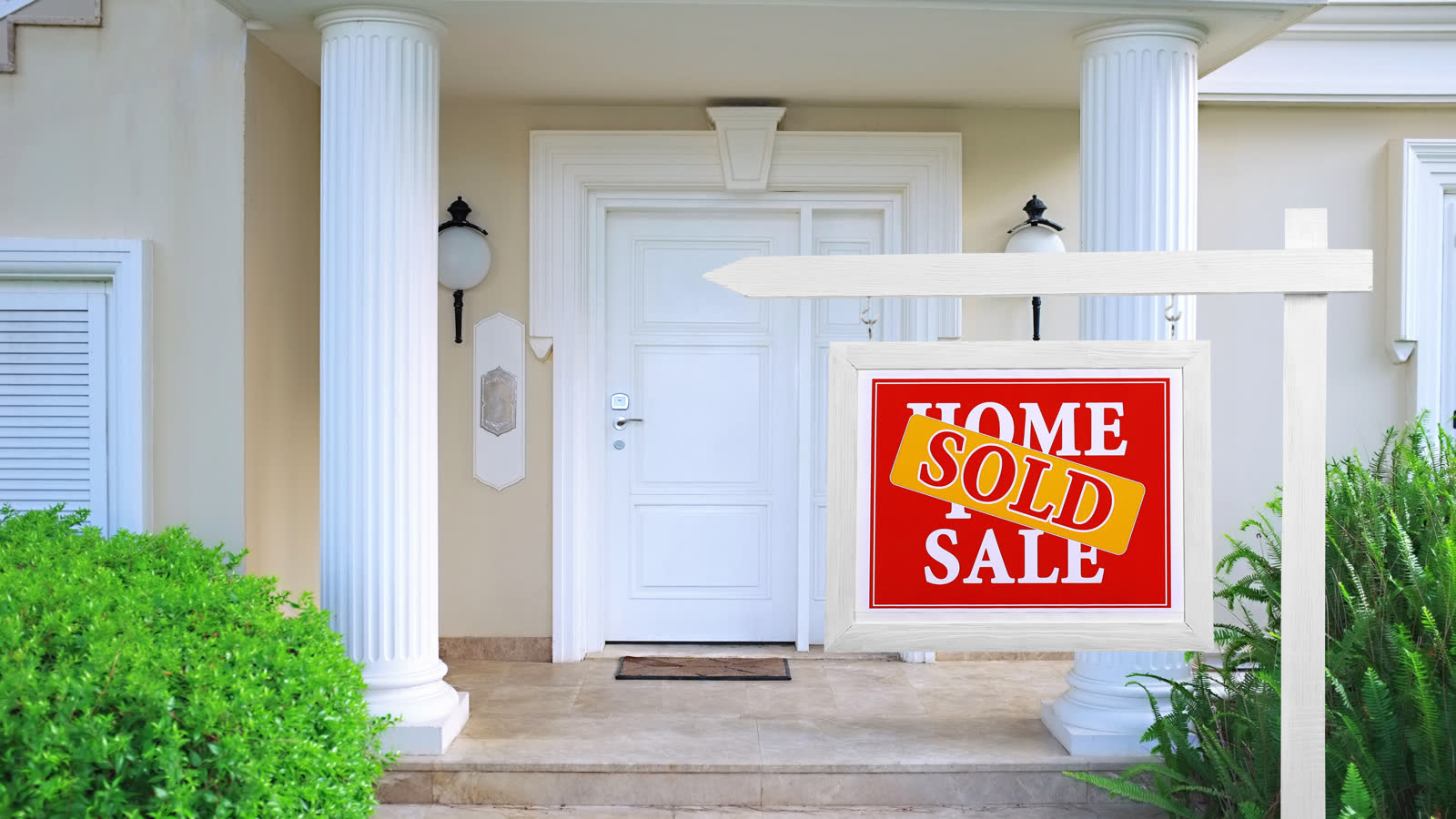 A sold sign standing in front of a house