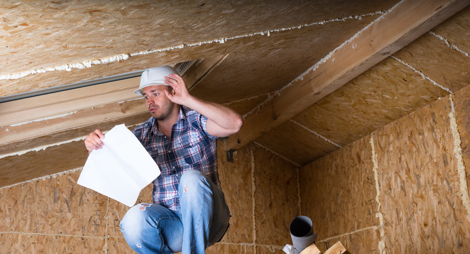 A person reading plans inside an unfinished house