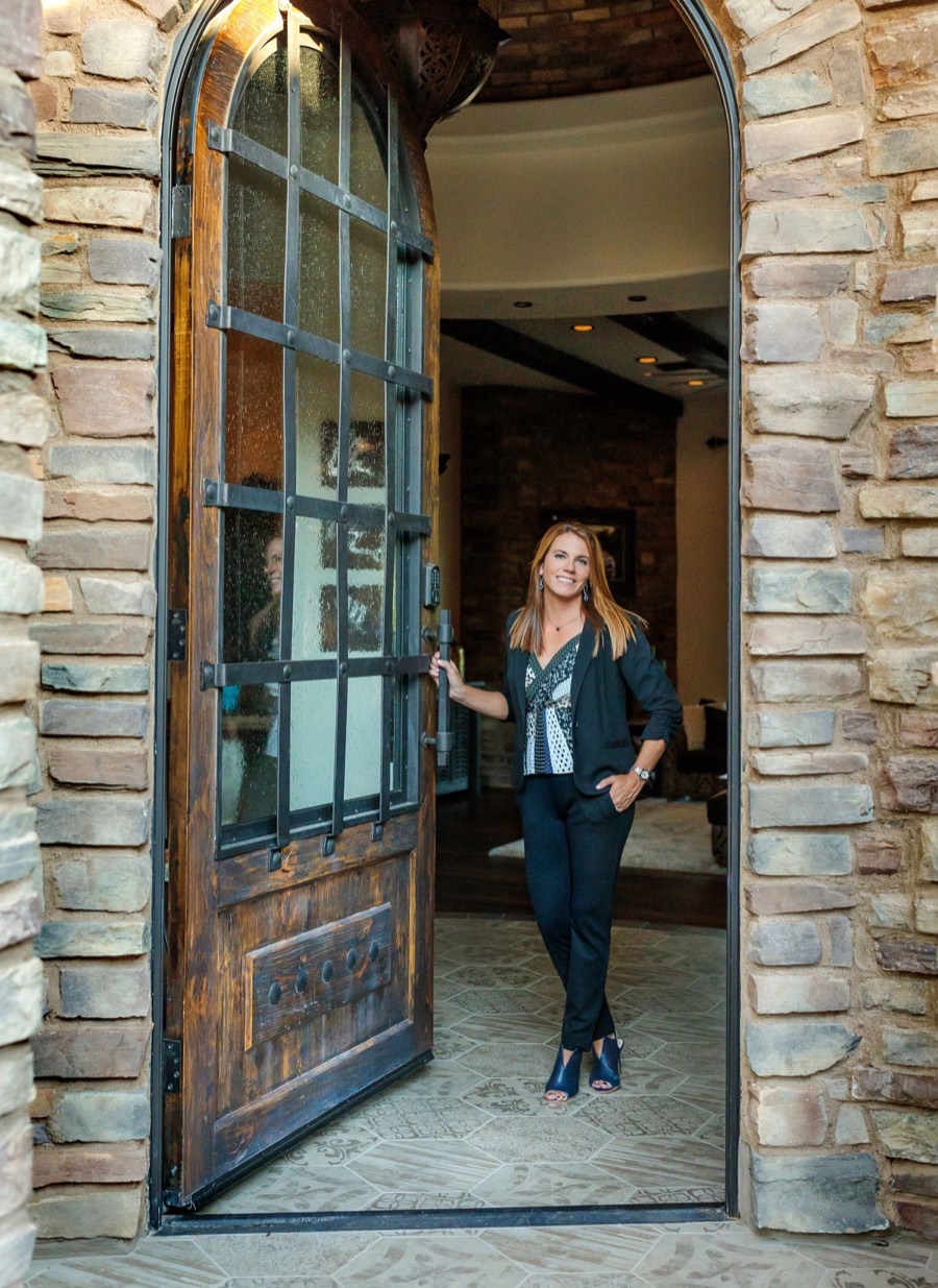 Amy Richardson opening a wooden front door